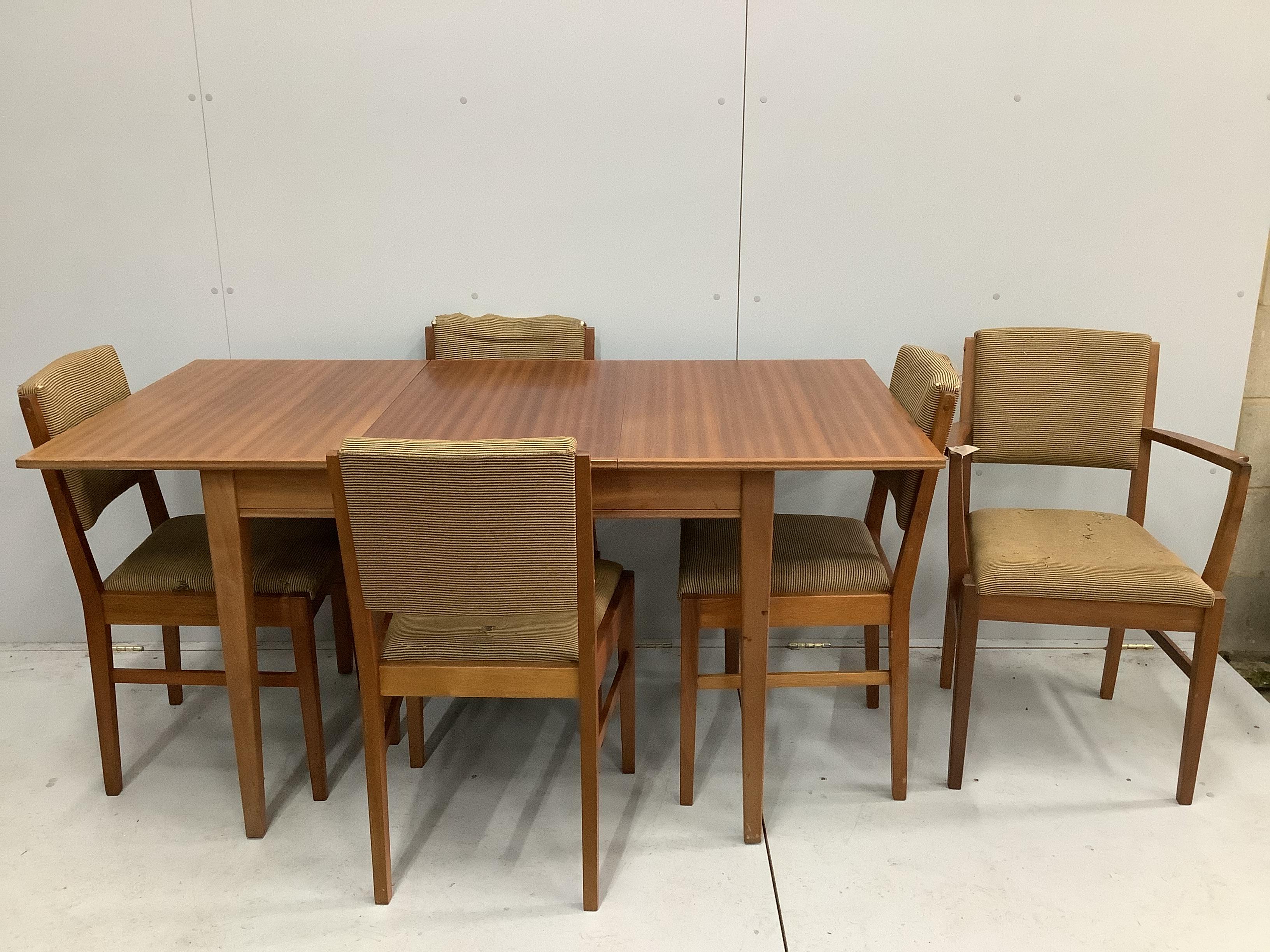 A Gordon Russell Broadway, mid century teak extending dining table, 153cm extended, width 78cm, height 77cm and five chairs, one with arms.